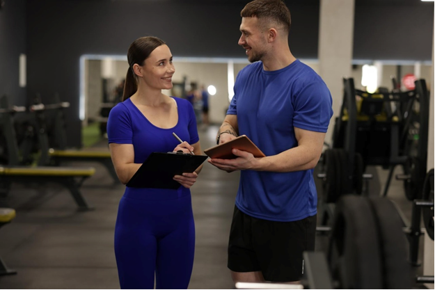 Personal trainer guiding a client through a strength training workout in a modern fitness gym